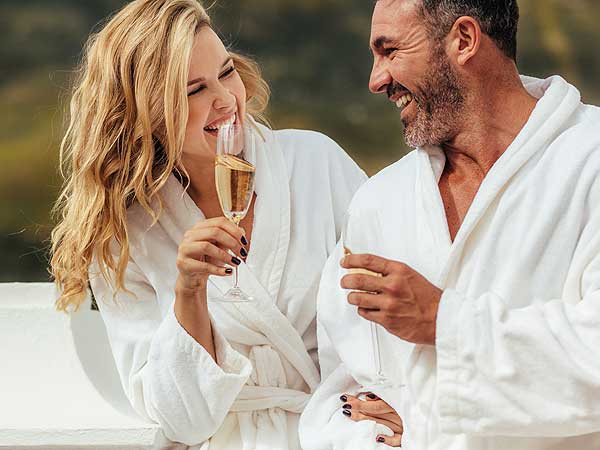 Couple in bathrobes drinking champagne in San Diego