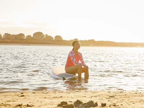 Girl sitting on a paddleboard.